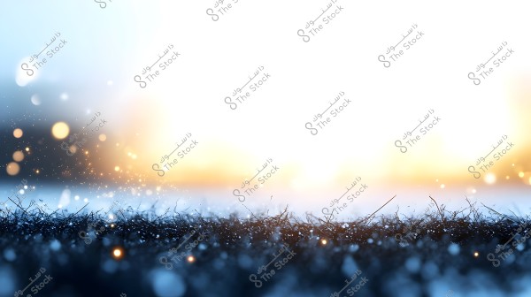 An abstract image depicting glistening water droplets on grass under the light of sunrise or sunset. The background transitions from dark blue to bright white, creating a captivating contrast with the golden light scattered across the scene.
