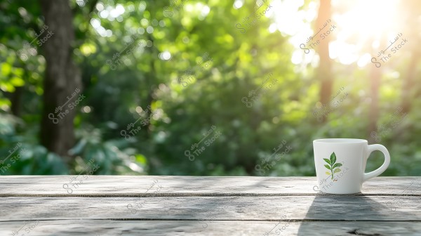 An image of a white mug with a plant design placed on a wooden table outdoors. The background features green trees with sunlight filtering through, creating a natural and peaceful atmosphere.