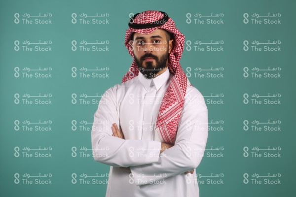 بورتريه رجل سعودي يرتدي الزي السعودي التقليدي يكتف ذراعيه