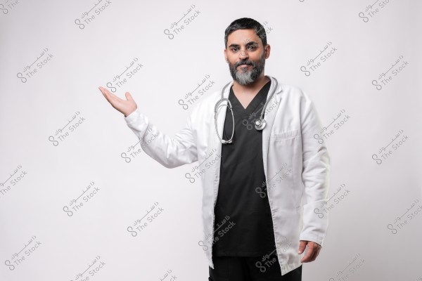 طبيب يرتدي معطفًا طبيًا ويضع سماعة حول عنقه, يمد يده بإيماءة ترحيب.