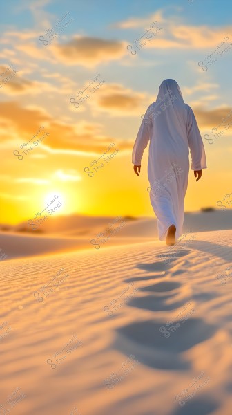 A person wearing a traditional white Arabic robe walking in the desert during sunset. The image shows sand dunes illuminated by the golden sunlight, with footprints left behind in the sand. The sky is partly cloudy with an orange sun on the horizon.