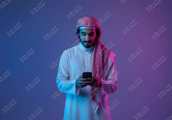 An image of a man wearing traditional Gulf attire and a red headscarf, standing against a vibrant blue and purple-lit background, holding a mobile phone and looking at it in a modern style.