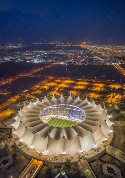 An overhead shot showing King Fahd International Stadium and landmarks of the city of Riyadh in the evening, buildings and landmarks, sports.