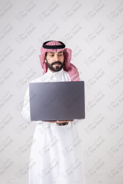 Portrait of a Saudi man holding a laptop and making different expressions, customer service, and communication.