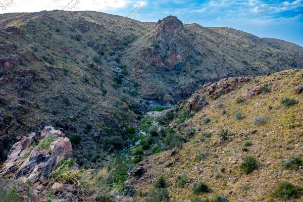 A beautiful mountain landscape with blue sky and stream flowing through the valley, from Al hada, Taif, Saudi Arabia