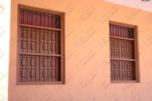 Detail of an old wooden window in a mud wall, decorative wooden window.