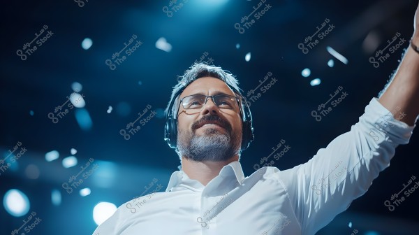 An image of a man wearing a white shirt and black headphones, standing and smiling in a brightly lit environment, appearing to enjoy music. The scene has a festive atmosphere with confetti scattered in the air.
