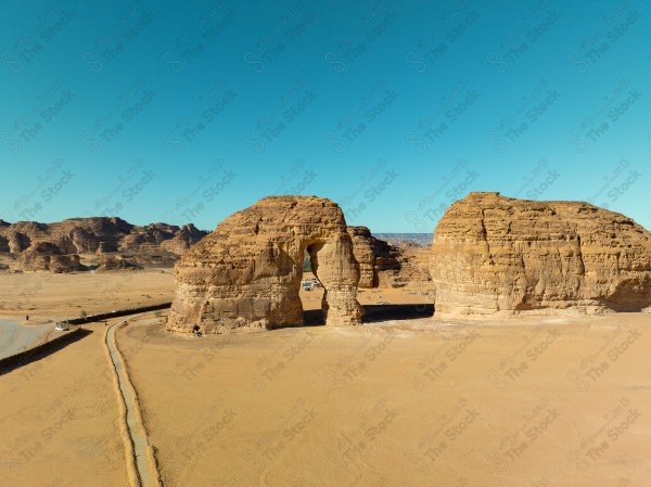 Image of a large rock formation known as Elephant Rock in AlUla, Saudi Arabia, under a clear blue sky.