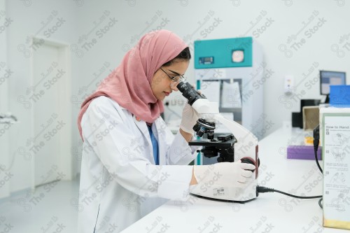 Saudi doctor in a hospital works in a laboratory, a medical team uses a microscope to examine a blood sample, and works in the field of health, providing medical consultations and medical health services.