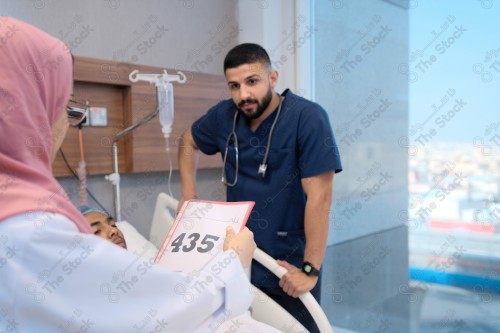 Saudi female doctor and paramedic in medical uniform and examining and applying nutritional solution, medicine and health care