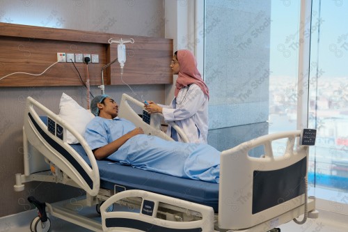 A Saudi female doctor wears a medical uniform and is examining and applying a nutrient solution, medicine and health care