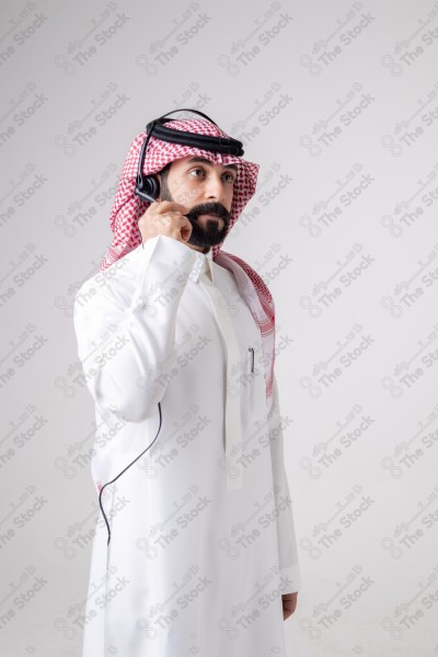 بورتريه رجل سعودي يلبس سماعة الرأس ويقوم بالتواصل عبر السماعة - خدمة العملاء ، مكالمة هاتفية