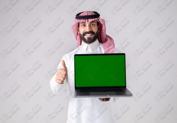 Portrait of a Saudi man holding a laptop, pointing at the laptop and making different expressions - green screen