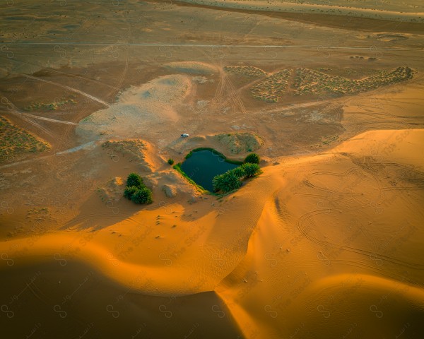 لقطة جوية لبحيرة برودان بالقرب من مدينة القصب، سلسلة من الكثبان الرملية، الطبيعة بالسعودية، بركة مياه.