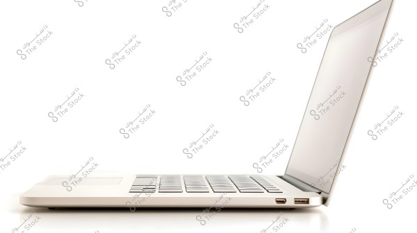 Image of an open silver laptop from a side angle. The view shows the right side of the laptop with a keyboard, USB ports, and the edge of the screen.