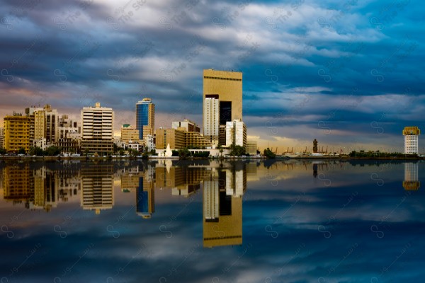 A shot of a group of buildings and landmarks at sunset showing the reflection of buildings in the water, buildings and landmarks, rivers and seas.