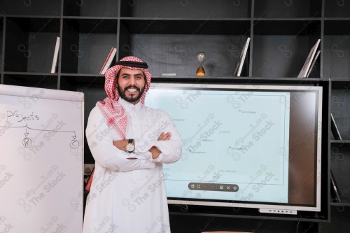 A Saudi man in traditional Saudi dress conducts a business meeting in the boardroom during the day