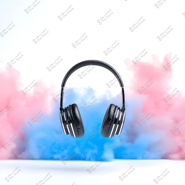 Black headphones floating in the air with a background of pink and blue colored smoke. The design is simple with eye-catching visual effects.