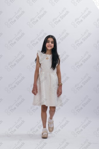 Portrait of a Saudi girl on a white background making gestures with her hands while smiling, souvenir photos, documenting a happy moment, Eid candy, Eid gifts, Eidiyat