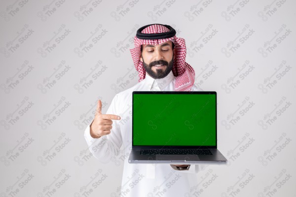 Portrait of a Saudi man holding a laptop, pointing at the laptop and making different expressions - green screen