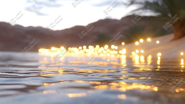 A natural scene showing a water surface with reflections of warm yellow lights, creating an enchanting atmosphere. In the background, there are palm trees and hills under a partly cloudy sky with shades of orange and pink from the sunset.