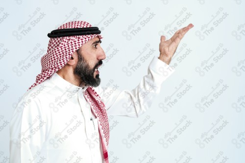 بورتريه رجل سعودي كبير بالسن يرتدي الزي الرسمي التقليدي على خلفية بيضاء يقوم بعمل اشارات بيديه وهو مبتسم ، حزين، غاضب، صور تذكارية ، توثيق لحظة سعيدة.