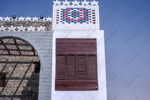 Detail of an old wooden window in a mud wall, decorative wooden window.