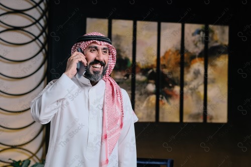 رجل سعودي يقوم بتفاعلات مختلفة باستخدام الجوال ، رجل سعودي يقوم بإجراء مكالمة هاتفية وهو مبتسم