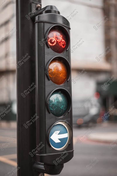 A traffic light for bicycles showing a red light with a bicycle icon, while the blue arrow at the bottom indicates a left turn.