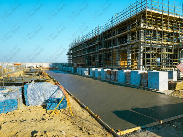 A construction site with a large building in the background. multi-storey building. A construction site with scaffolding and a large building in the background.