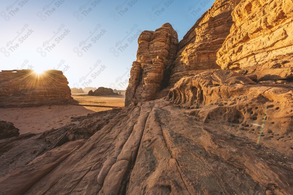 لقطة جوية لسلسلة من الجبال الصخرية في وادي الديسة بتبوك في السعودية وتظهر السماء صافية نهارًا، صخور وجبال.