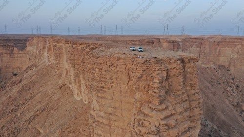 لقطة جوية لمجموعة سياح على جبل من جبال طويق المسمى بحافة العالم. سلسلة من الجبال الصخرية