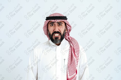 بورتريه رجل سعودي كبير بالسن يرتدي الزي الرسمي التقليدي على خلفية بيضاء يقوم بعمل اشارات بيديه وهو مبتسم ، حزين، غاضب، صور تذكارية ، توثيق لحظة سعيدة.