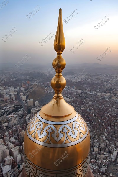 قمة برج الساعة الذهبية في مكة المكرمة تظهر فوق المدينة عند غروب الشمس.