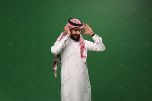 بورتريه رجل سعودي يرتدي الزي السعودي التقليدي يعدل شماغه