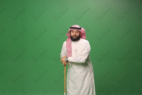 بورتريه رجل سعودي يرتدي الزي السعودي التقليدي يتكئ على العصا أثناء أداء رقصة المزمار الحجازية