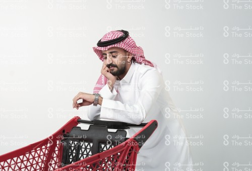 رجل سعودي يبدو متعبًا من التسوق