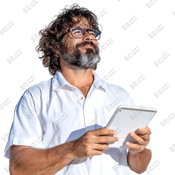 A portrait of a bearded man with long curly hair, wearing glasses and a short-sleeved white shirt. He is looking upwards and holding a tablet with both hands. The background is entirely white.