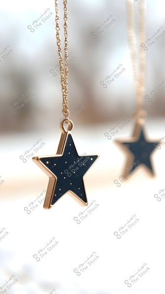 Image of a star-shaped pendant in a gold color with a dark blue inlay, hanging on a gold chain. The background is blurred with another part of the pendant visible in the distant background.