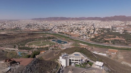 لقطات جوية لمدينة تظهر تضاريس طبيعية خلابة تتضمن جبالاً وحدائق وبرك مائية, بالإضافة إلى انتشار المناطق السكنية على امتداد النظر.\r\n\r\n-