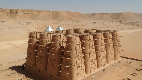 طائرة بدون طيار تحلق فوق برج حمام عربي مهجور من الطوب اللبن في منطقة الرياض بالمملكة العربية السعودية.