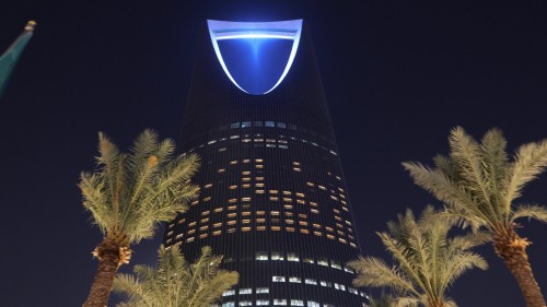 فيديو ليلي يعرض برج المملكة في الرياض مضاءً بأنوار زرقاء, مع العلم السعودي وأشجار النخيل المحيطة به.\r\n\r\n-