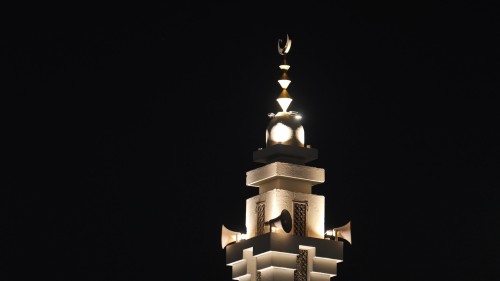 The video shows nighttime shots of a mosque\'s minaret illuminated with warm lights, highlighting its beautiful architectural details in the darkness, creating an atmosphere of tranquility and serenity.\r\n\r\n-