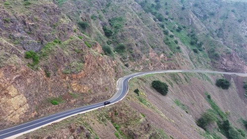 فيديو يُظهر مناظر خلابة لسيارة تسير على طريق ملتوي بين جبال خضراء وصخرية, مع مشاهد طبيعية خلابة تبرز تضاريس المنطقة الجبلية.\r\n\r\nبجازان