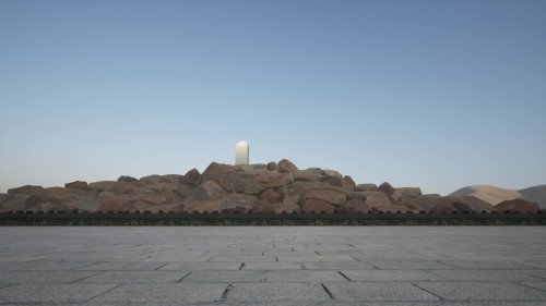 The video shows a serene view of a Arafat mountain made of rocks in an open area with a clear blue sky in the background and a tall pillar or monument at the top.