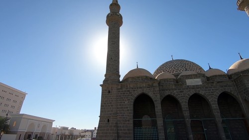 فيديو يعرض لقطات من مسجد العنبرية في المدينة بمآذن عالية وقبة كبيرة وتصميم معماري مميز, تحت أشعة الشمس الساطعة.
