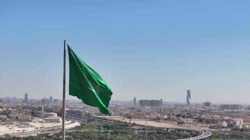 The video shows footage of the Saudi Arabian flag waving in the wind against a panoramic view of Riyadh city, featuring modern buildings and major roads in the city’s expansive skyline.\r\n\r\n-