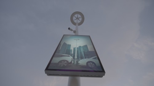 The video showcases smart light poles in a modern city, equipped with interactive displays providing information about electric vehicle charging and skyscrapers in the background. It highlights technological innovations in infrastructure and sustainable energy improvements in urban areas.