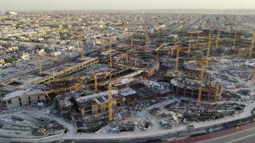 Aerial shots of a large construction site with numerous cranes in a bustling city, showcasing the development of modern infrastructure.